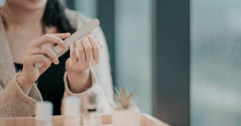 an asian chinese teenage girl polishing and coloring her finger nail